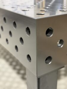 Modularer Schweißtisch mit Lochraster und Spannsystem zum präzisen Fixieren eines Stahlrahmens in der Werkstatt