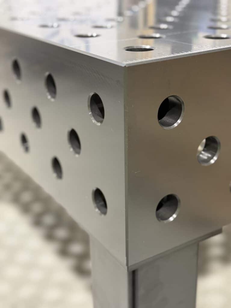 Modularer Schweißtisch mit Lochraster und Spannsystem zum präzisen Fixieren eines Stahlrahmens in der Werkstatt
